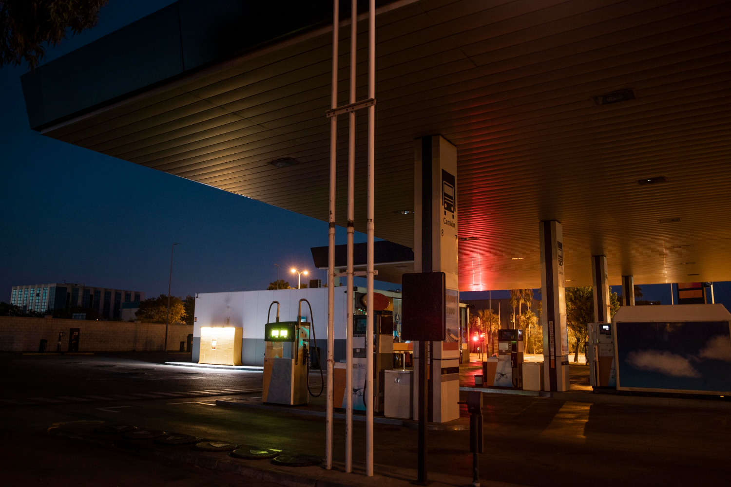station-service atra déserte la nuit à gaillac, éclairage doux sur les pompes et sol mouillé