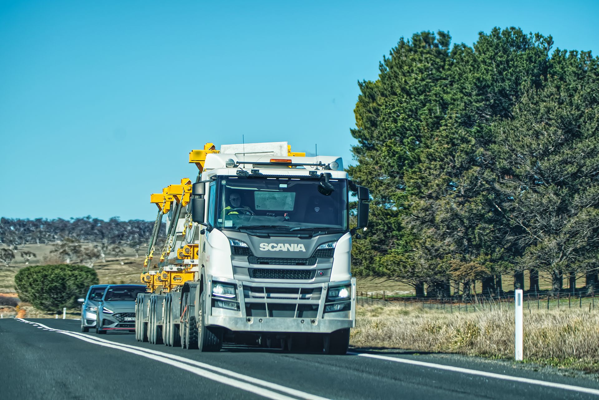 Camion atra transport exceptionnel sur route de campagne près de Gaillac sous un ciel bleu dégagé